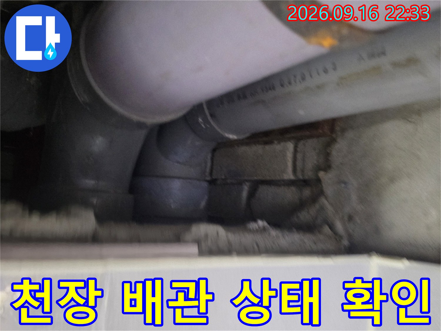 천장 내부의 배관 연결 부위와 하수관 노출 상태를 보여주는 사진입니다.