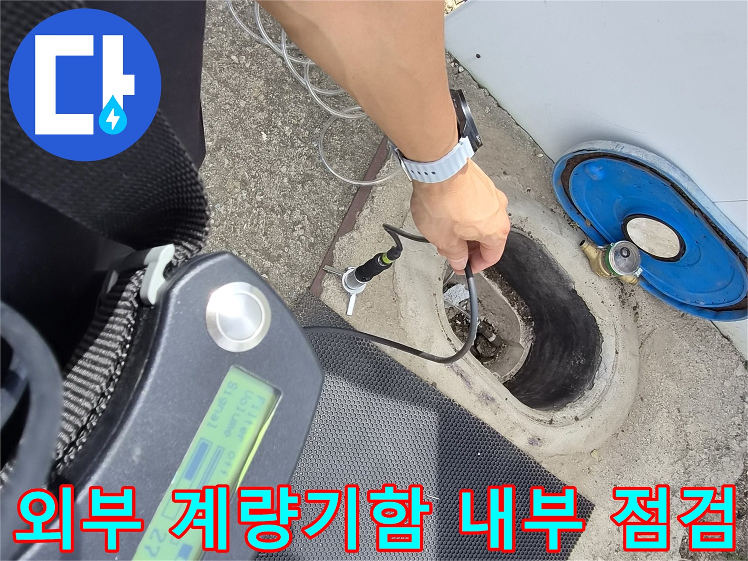 푸른색 덮개가 있는 계량기 함 안쪽의 배관 연결 부위를 청음기로 검사하는 사진