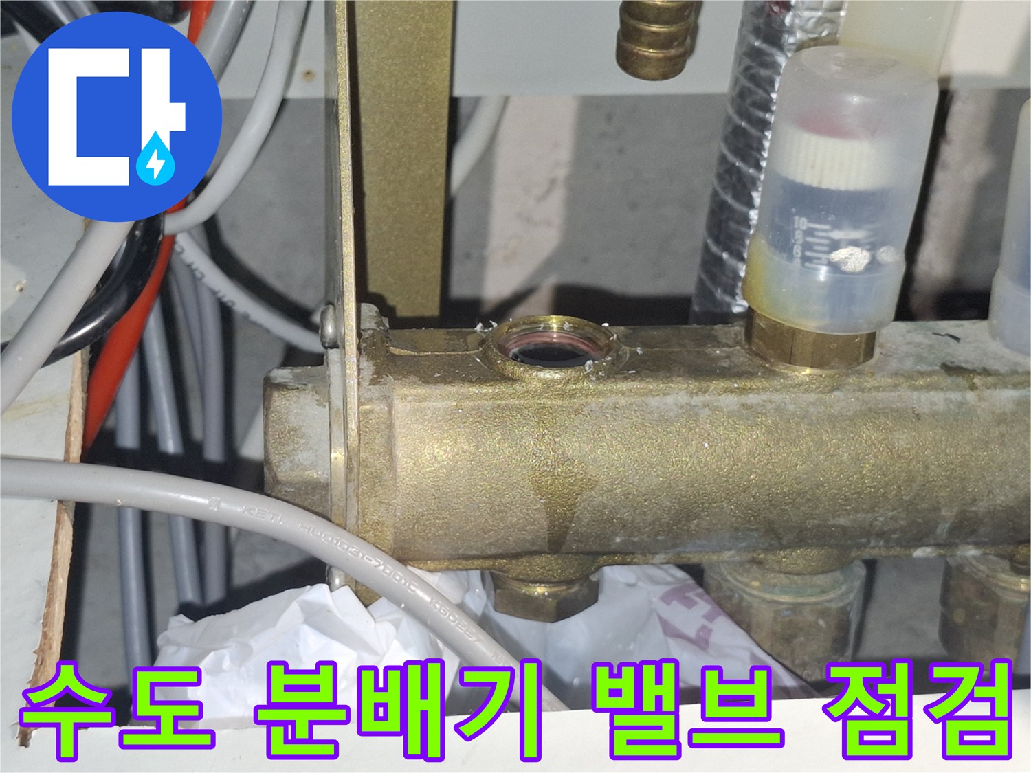황동색 수도 분배기-배관 연결 부위 근접 사진