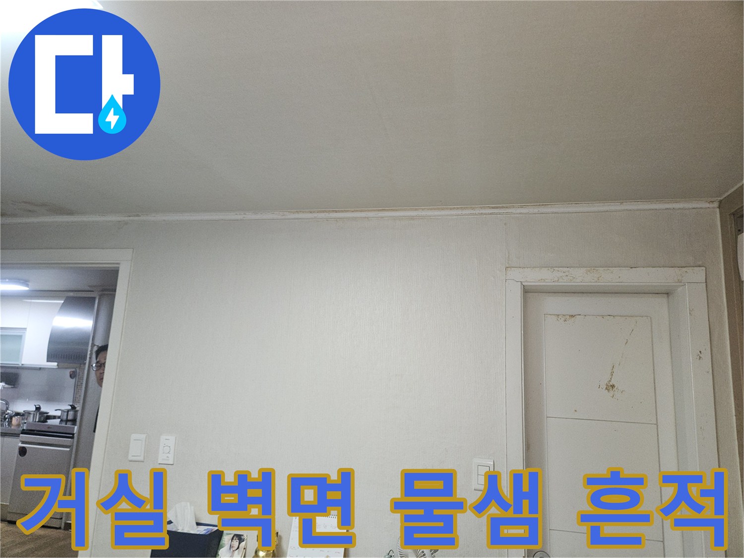 문틀 아래쪽의 변색된 벽지와 습기가 찬 모습