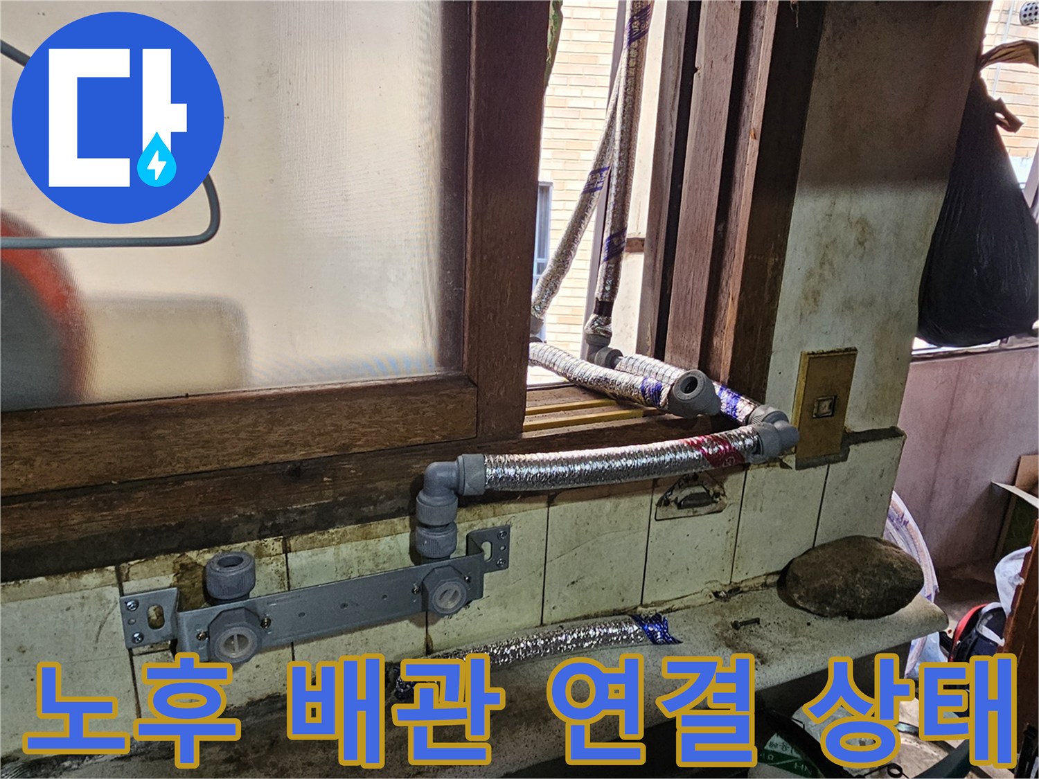 외부로 노출된 은색 호스와 불규칙한 배관 연결 부위입니다.