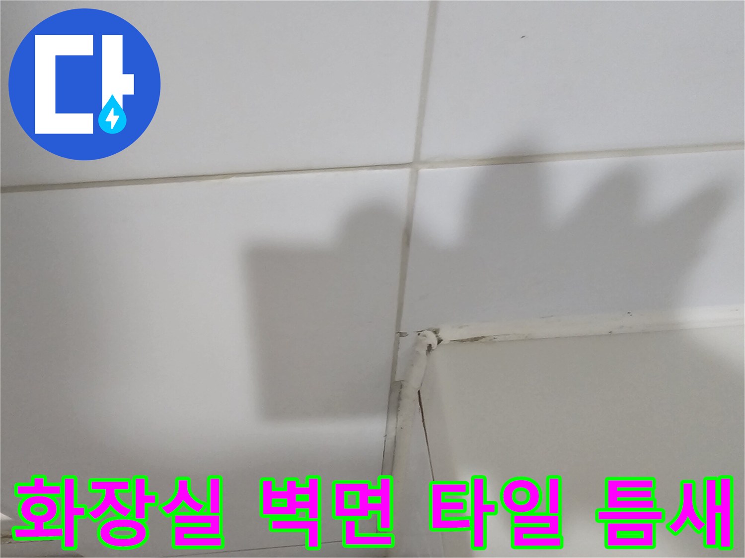 하얀색 욕실 타일 사이의 줄눈 상태를 근접 촬영한 이미지입니다.